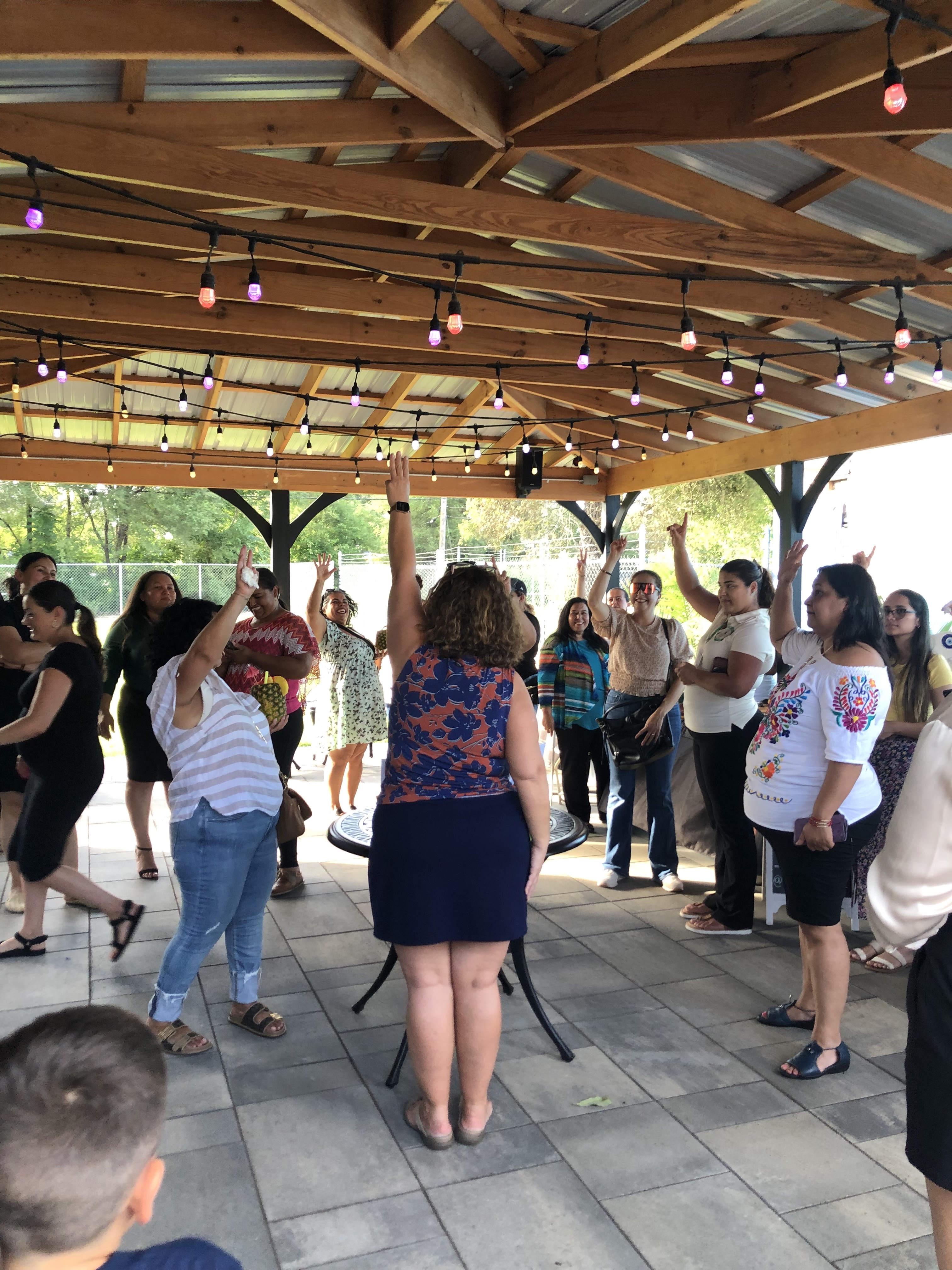 a group of women facing opposite to the camera raising their hands at networking event